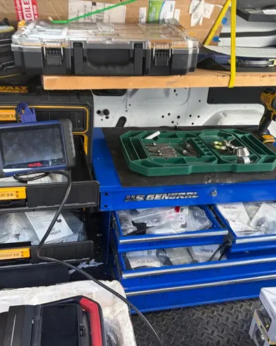 Autel key programming tablet on a tool chest full of key blanks and parts in the van